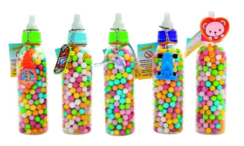 Babyfläschchen mit Zuckerperlen und Spielzeug